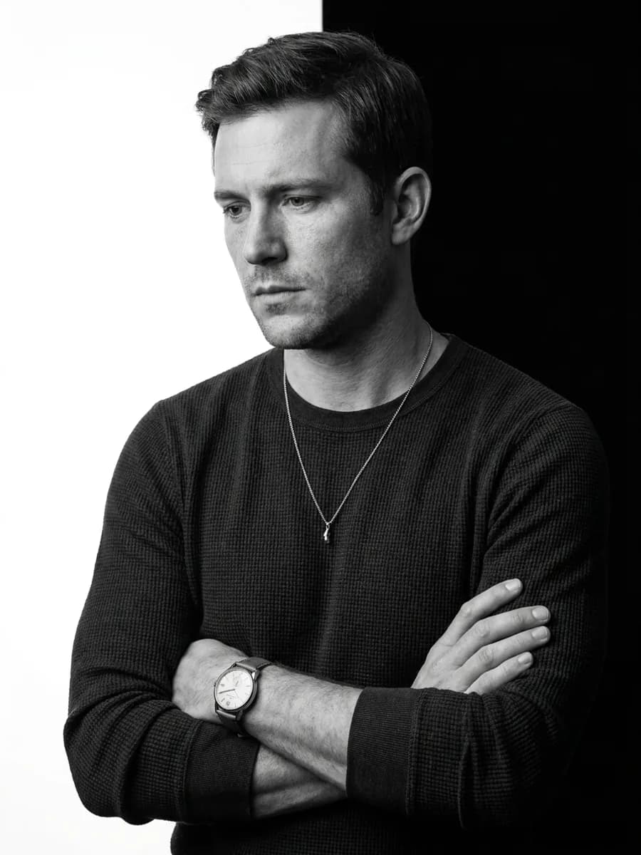 A stunning black and white studio portrait of the uploaded person. Eye-level med